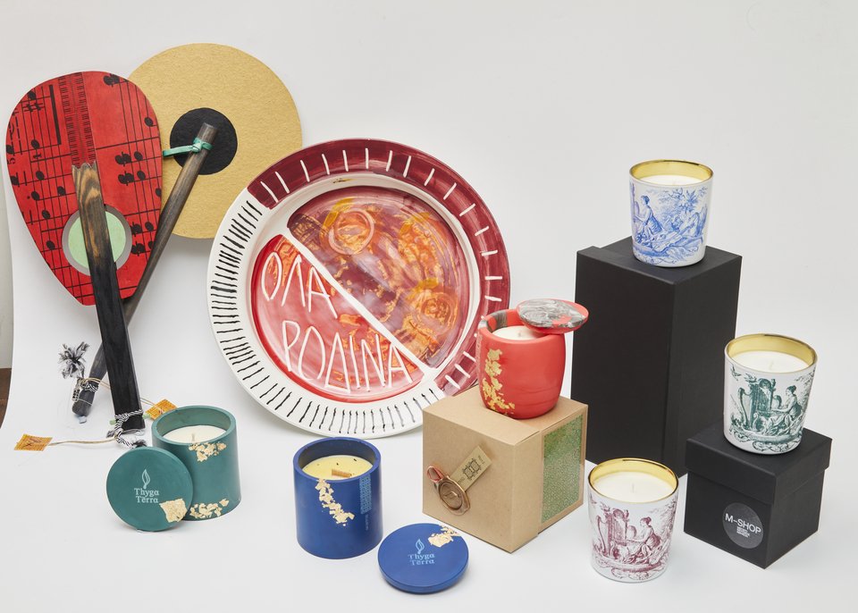 Χειροποίητες βεντάλιες «Chrisma58», με πρωτότυπα χρώματα και φύλλα από χρυσό, ασήμι και χαλκό, αποκλειστικά σχεδιασμένες για το Μ Shop του Μεγάρου Μουσικής Αθηνών:  | Κηροπήγια Τhygga Terra, φτιαγμένα από οικολογικά, βιώσιμα υλικά:  | Kεραμική πιατέλα ζωγραφισμένη στο χέρι από την Α. Μωραΐτη:  | Kεριά αποκλειστικά σχεδιασμένα από αρχεία συλλεκτικών εκδόσεων του Μεγάρου Μουσικής Αθηνών για το Μ Shop