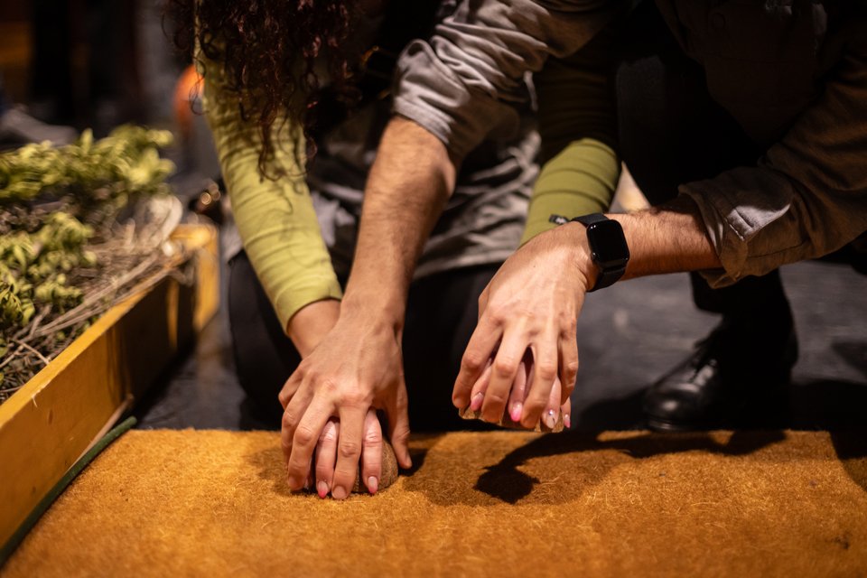 Ο Γιώργος οδηγεί τα χέρια συμμετέχουσας στην αισθητηριακή ξενάγηση, προκειμένου να χτυπήσουν τις καρύδες στο ξύλο, στον ρυθμό ενός αλόγου που καλπάζει / Πηνελόπη Γερασίμου