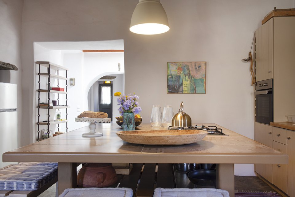 Μια νησίδα στην καρδιά της κουζίνας λειτουργεί ταυτόχρονα ως τραπέζι και ως πάγκος μαγειρικής με την εστία.