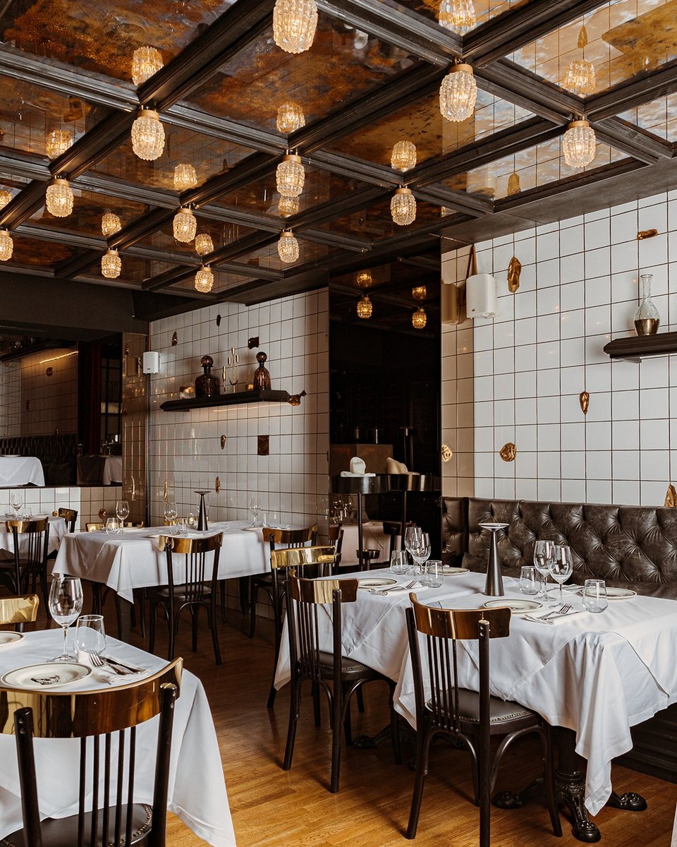 Η σάλα του Brutus Tavern παίζει διακοσμητικά με μια θεατρική παλέτα που συνδυάζει μαύρο, χρυσό και λευκό / Φωτογραφία: brutustavern/Instagram