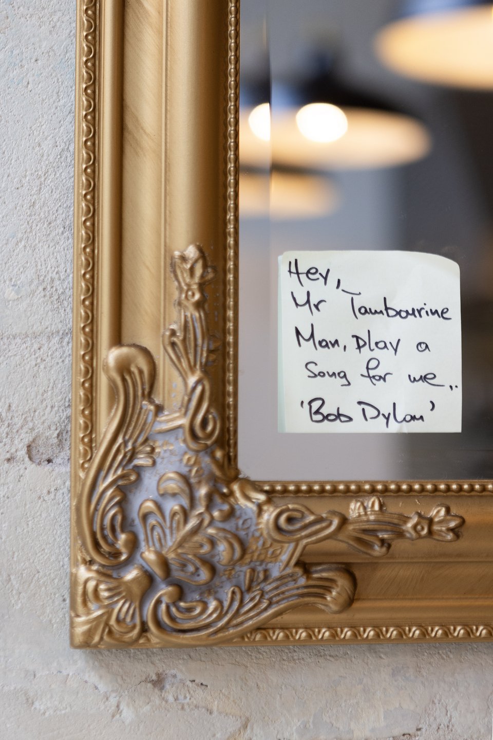 Στίχος του Μπομπ Ντύλαν σε post-it κολλημένο στον καθρέφτη με τη χρυσαφί κορνίζα.