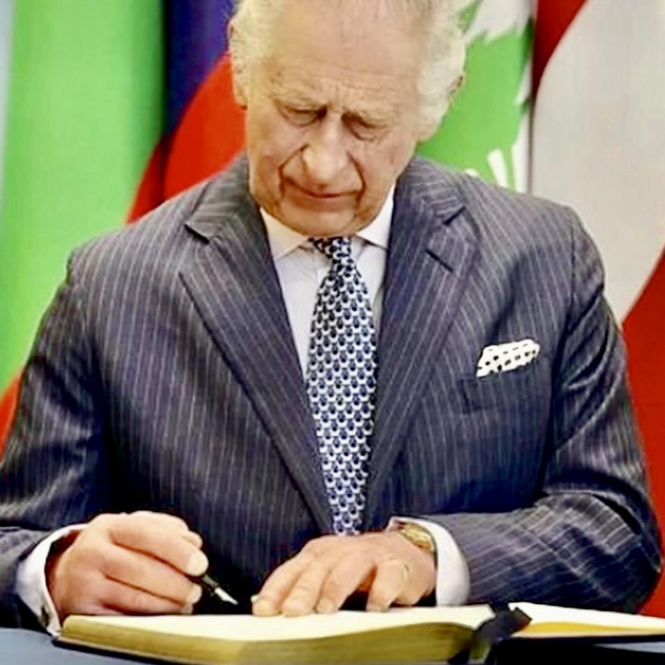 Ο Κάρολος υπογράφοντας σε διεθνές συνέδριο φορώντας τη γραβάτα με το σχέδιο Κουκουβάγια