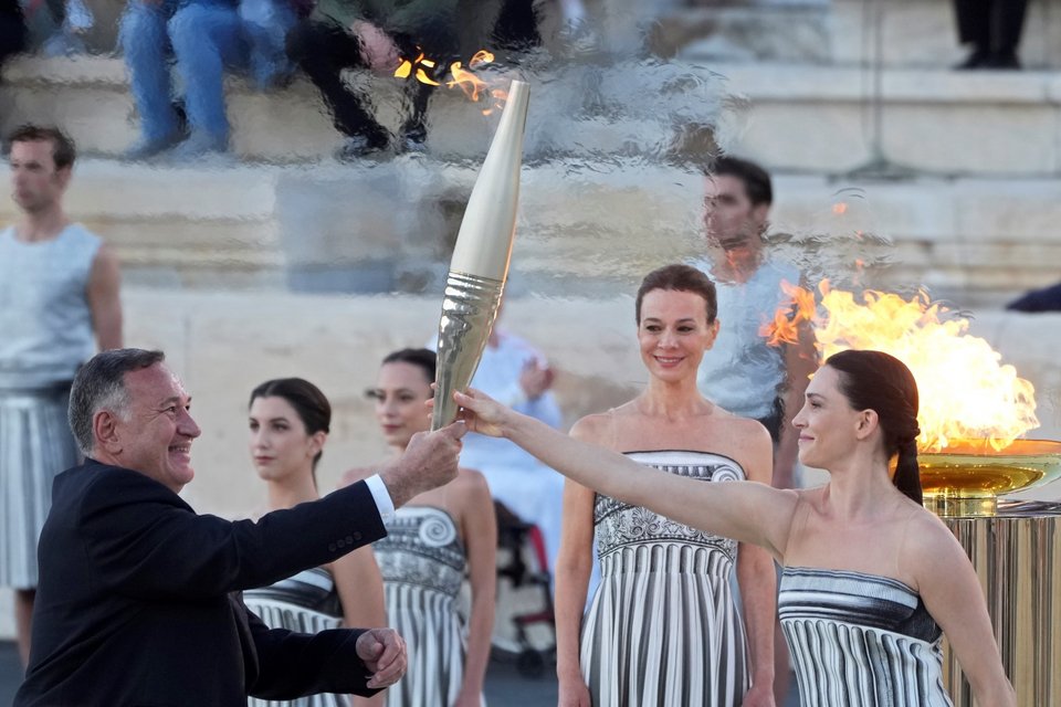 Η ηθοποιός Μαρία Μινά, πρωθιέρεια της Ολυμπιακής Φλόγας, παραδίδει τη φλόγα στον πρόεδρο της ΕΟΕ, Σπύρο Καπράλο / Φωτογραφία: AP Photo/Petros Giannakouris