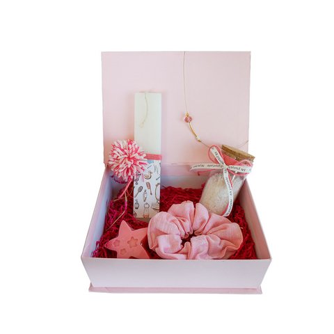 Πασχαλινό σετ για κορίτσι, με λαμπάδα σε λευκό πλακέ αρωματικό κερί. Το σετ περιλαμβάνει άλατα μπάνιου, σαπουνάκι πούδρα, λαστιχάκι μαλλιών σε ροζ χρώμα και χειροποίητο κολιέ. Η λαμπάδα είναι δημιουργία της ομάδας εθελοντών του  Εργαστηρίου του Οργανισμού μας