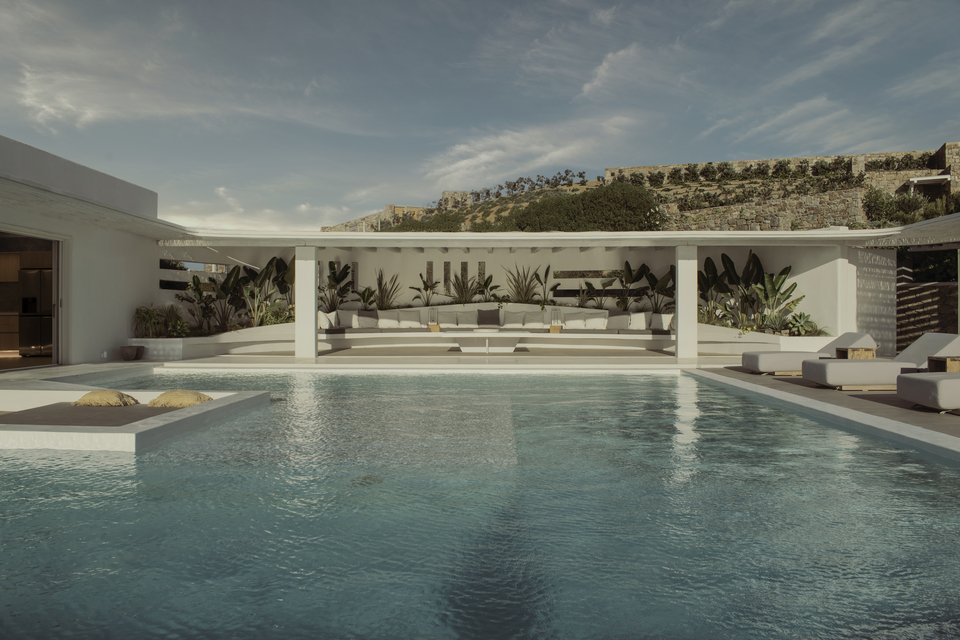 H εντυπωσιακή πισίνα και το lounge κάτω από τη λευκή πέργκολα μοιάζουν με σκηνικό ταινίας.