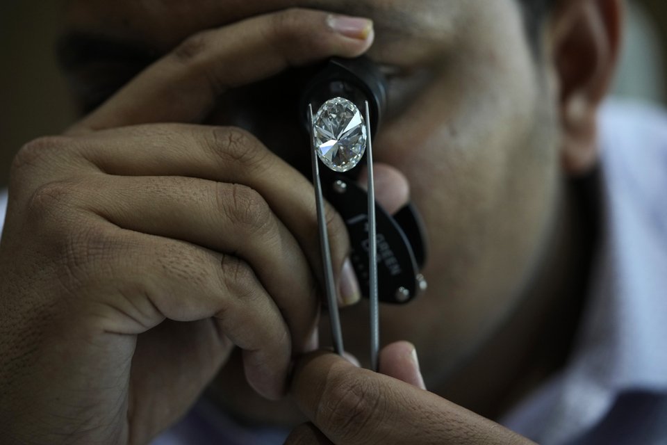 Ένας άνδρας κοιτάζει ένα γυαλισμένο εργαστηριακό διαμάντι στο Greenlab Diamonds