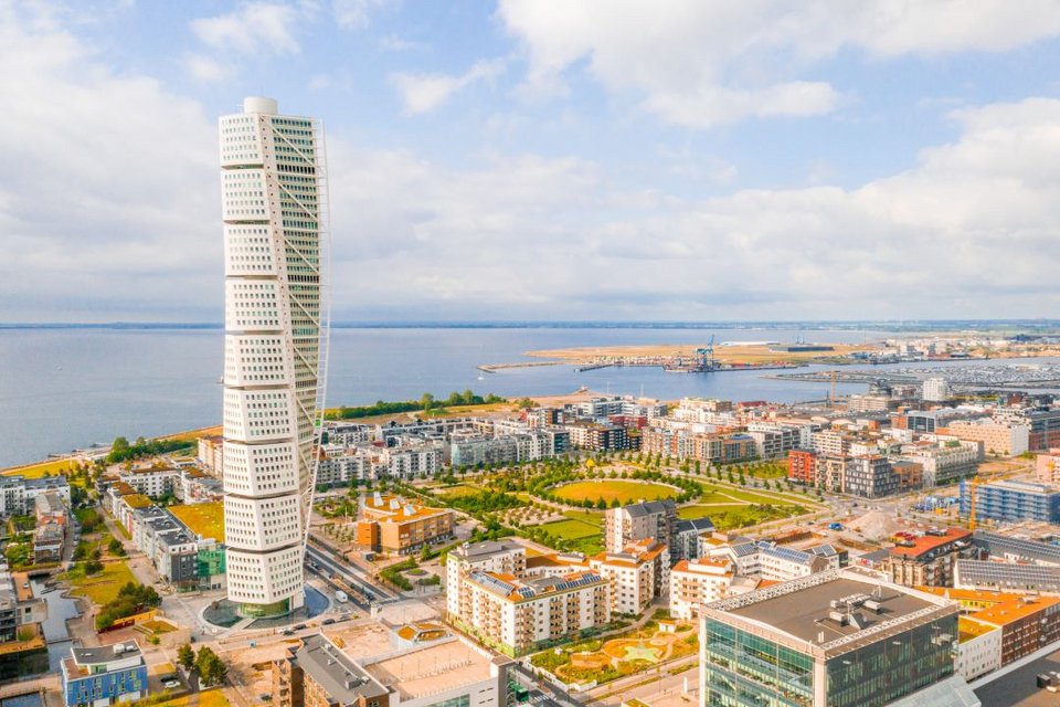 Μια πόλη δίπλα στη θάλασσα με παλαιά κτίρια και σύγχρονο ουρανοξύστη.