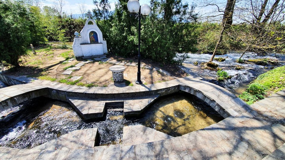 Ενα υπαίθριο βαπτιστήριο κάτω από τα αιωνόβια πλατάνια και τις οξείες, δίπλα στα τρεχούμενα γάργαρα νερά