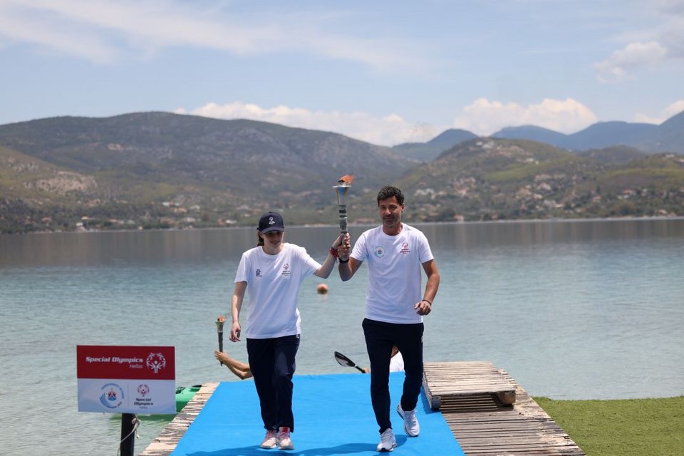 Η Αλεξάνδρα Μέγα, αθλήτρια στίβου των Special Olympics Hellas, με τον Νικόλαο Αγγελάκη, ανθυπαστυνόμο της Ελληνικής Αστυνομίας και επίσημο λαμπαδηδρόμο των Special Olympics Hellas, παραλαμβάνουν τη Φλόγα της Ελπίδας / Φωτογραφία: Stelios Misinas