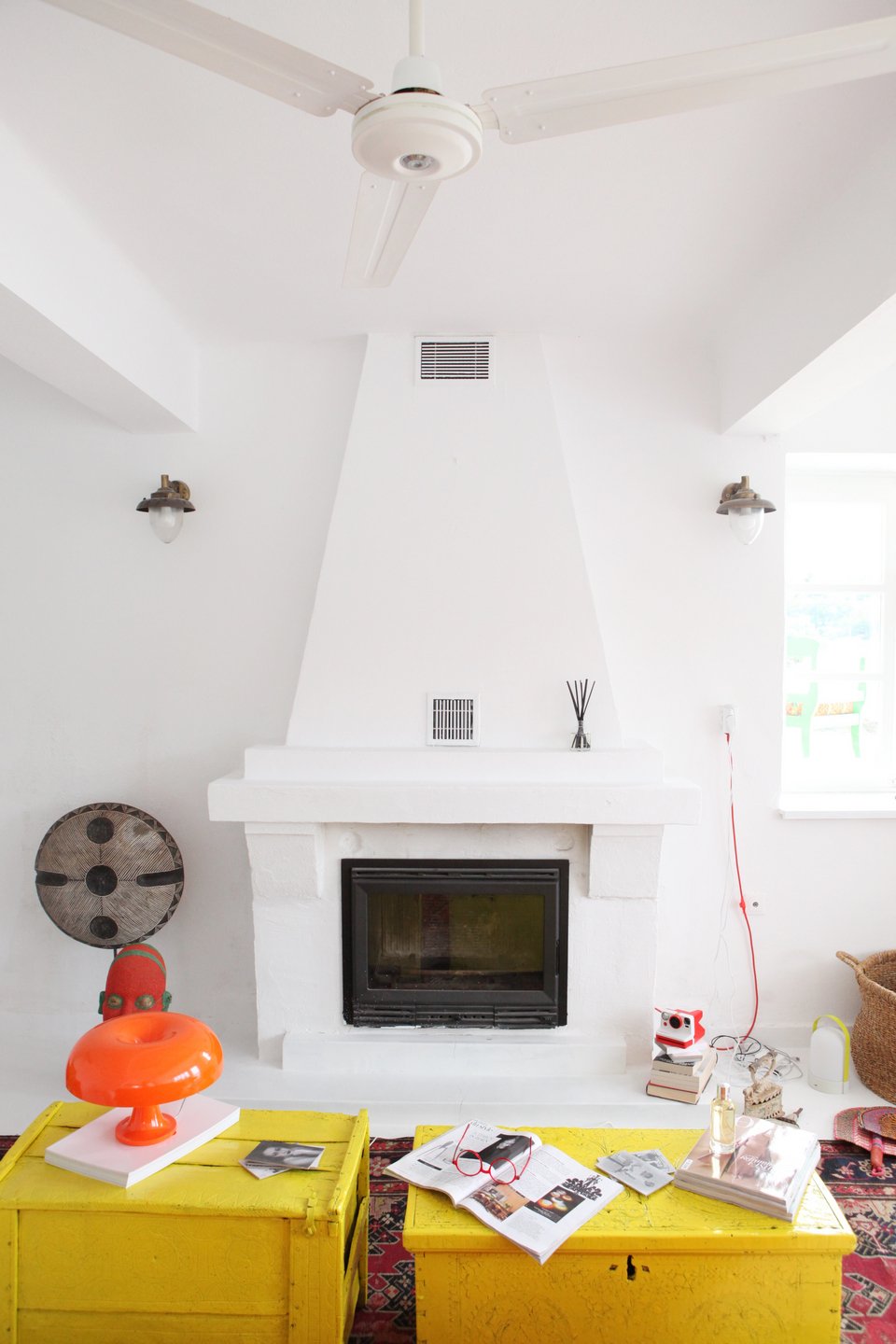 To τζάκι στο σαλόνι με το 70ies ρετρό φωτιστικό / Φωτογραφία: Courtesy of George Carabellas