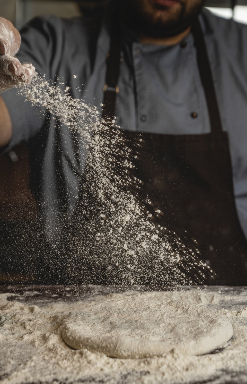 Μέσα στην κουζίνα, καθώς φτιάχνεται η χειροποίητη ζύμη της πίτσας.