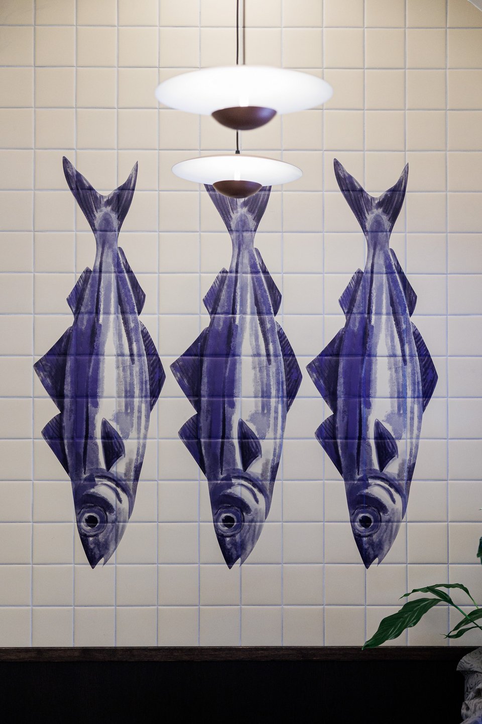 Ζωγραφισμένα ψάρια στα πλακάκια που ντύνουν την ψαριέρα του Piscis. 