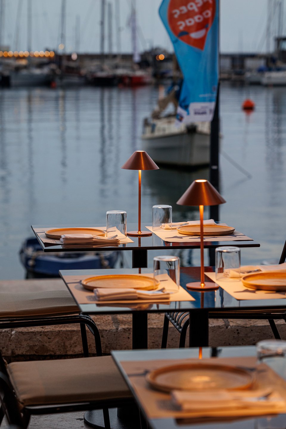 Tα τραπέζια του Piscis κάτω από τη μεταλλική πέργκολα στο Μικρολίμανο. 