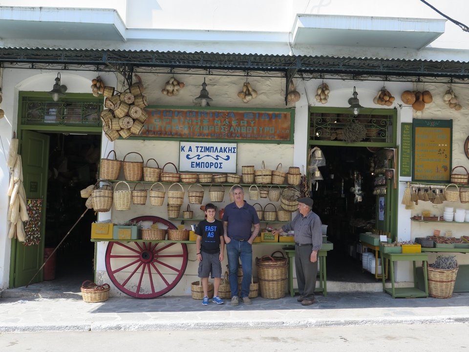 Οι τρεις γενιές του παντοπωλείου Τζιμπλάκης σε παλαιότερη φωτογραφία - Από αριστερά: Ο Αντώνης Τζιμπλάκης, ο γιος του Κυριάκος και ο εγγονός του Αντώνης, φωτογραφημένοι στην πρόσοψη του μαγαζιού τους στη Νάξο. 