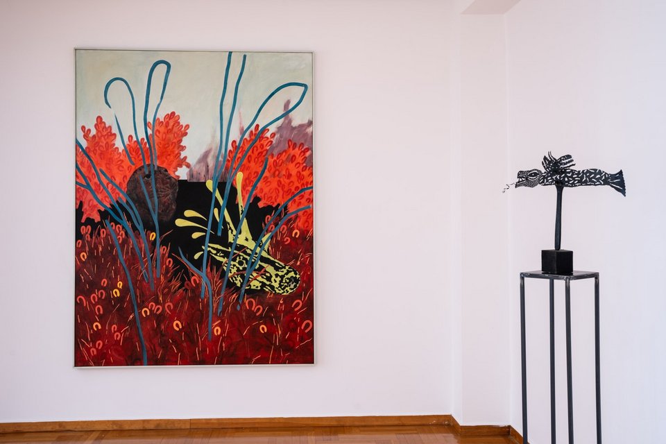 Φωτογραφία εγκατάστασης Μυθιστορίες ΙΙ. Ιάσονας Καμπάνης, Το Λιοντάρι της Χεβρώνας και το Ιερό Ελάφι, 2024, 200 x 150 εκ., ακρυλικό και γκέσο σε ύφασμα επικολλημένο σε ξύλο (αριστερά). Τάσος Μαντζαβίνος, Κατασκευή ΙΙ, 2017, 43 x 7 x 7 εκ., μικτή́ τεχνική (δεξιά). Παραχώρηση του καλλιτέχνη και της CITRONNE Gallery © Alexandra Masmanidi