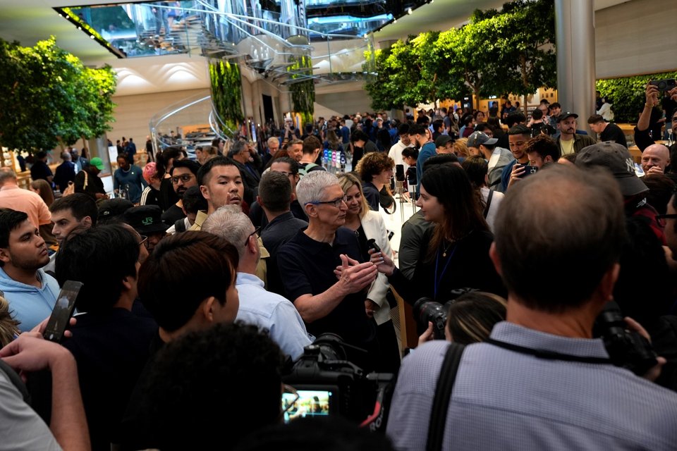 Ο διευθύνων σύμβουλος της Apple, Tim Cook (στο κέντρo), μιλάει με ανθρώπους στο κατάστημα Apple στη Fifth Avenue για την κυκλοφορία του iPhone 16