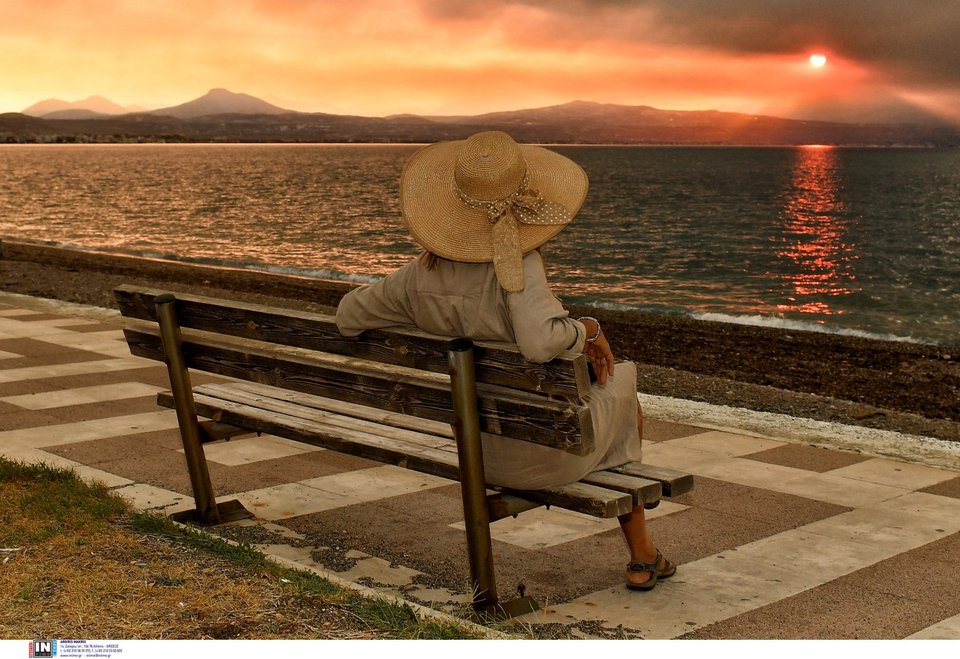 Μια γυναίκα στον Ισθμό βλέπει τους καπνούς από τα Ροζεννά Κορινθίας -Φωτογραφία: Intimenewws/ΨΩΜΑΣ ΒΑΣΙΛΗΣ
