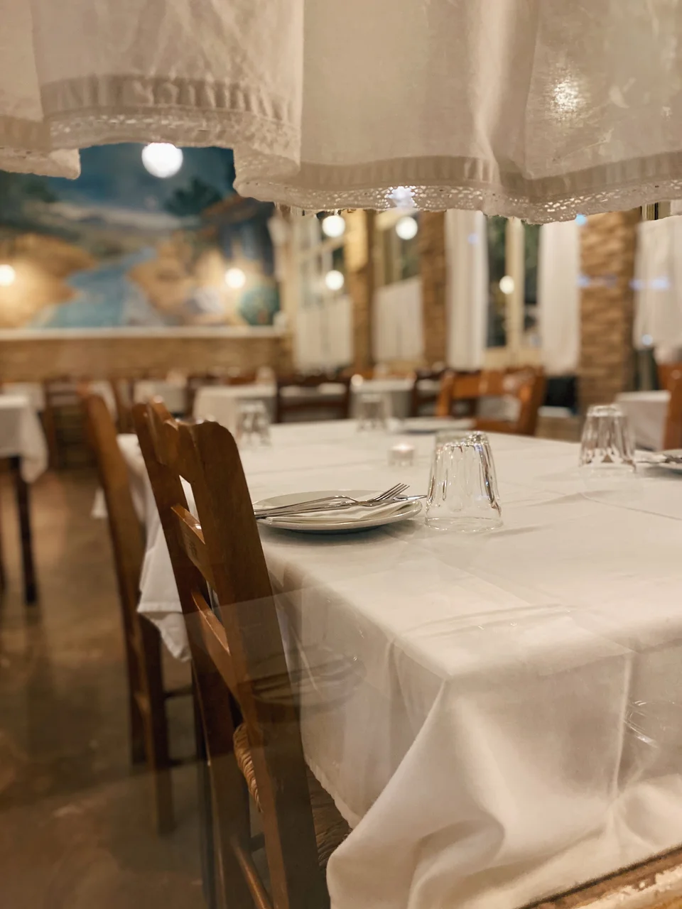 Η σάλα της Ταβέρνας των Φίλων όπως φαίνεται στους περαστικούς από την τζαμαρία με τις λευκές κουρτίνες / Φωτογραφία: Μάνος Λειβαδάρος/iefimerida