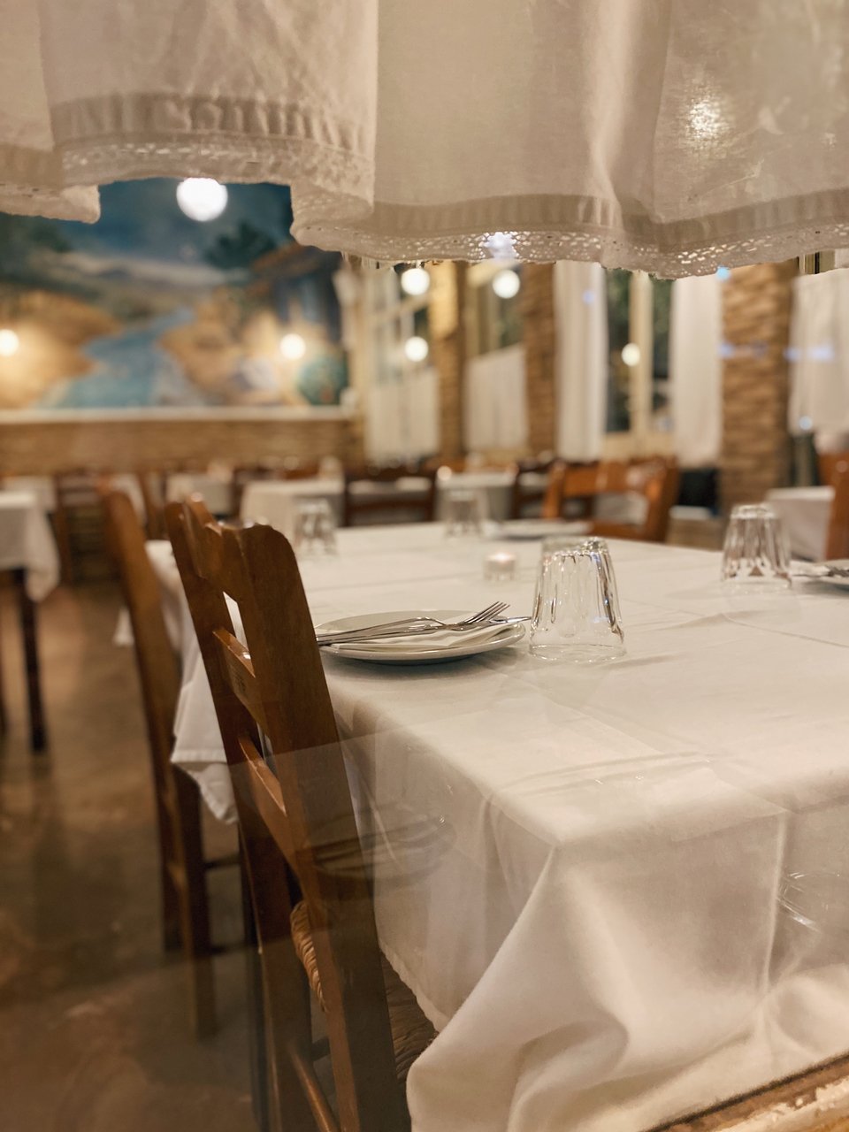 Η σάλα της Ταβέρνας των Φίλων όπως φαίνεται στους περαστικούς από την τζαμαρία με τις λευκές κουρτίνες / Φωτογραφία: Μάνος Λειβαδάρος/iefimerida