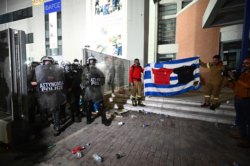 Κρατώντας την ελληνική σημαία εποχικοί πυροσβέστες έξω από το υπουργείο Πολιτικής Προστασίας / Φωτογραφία: EUROKINISSI