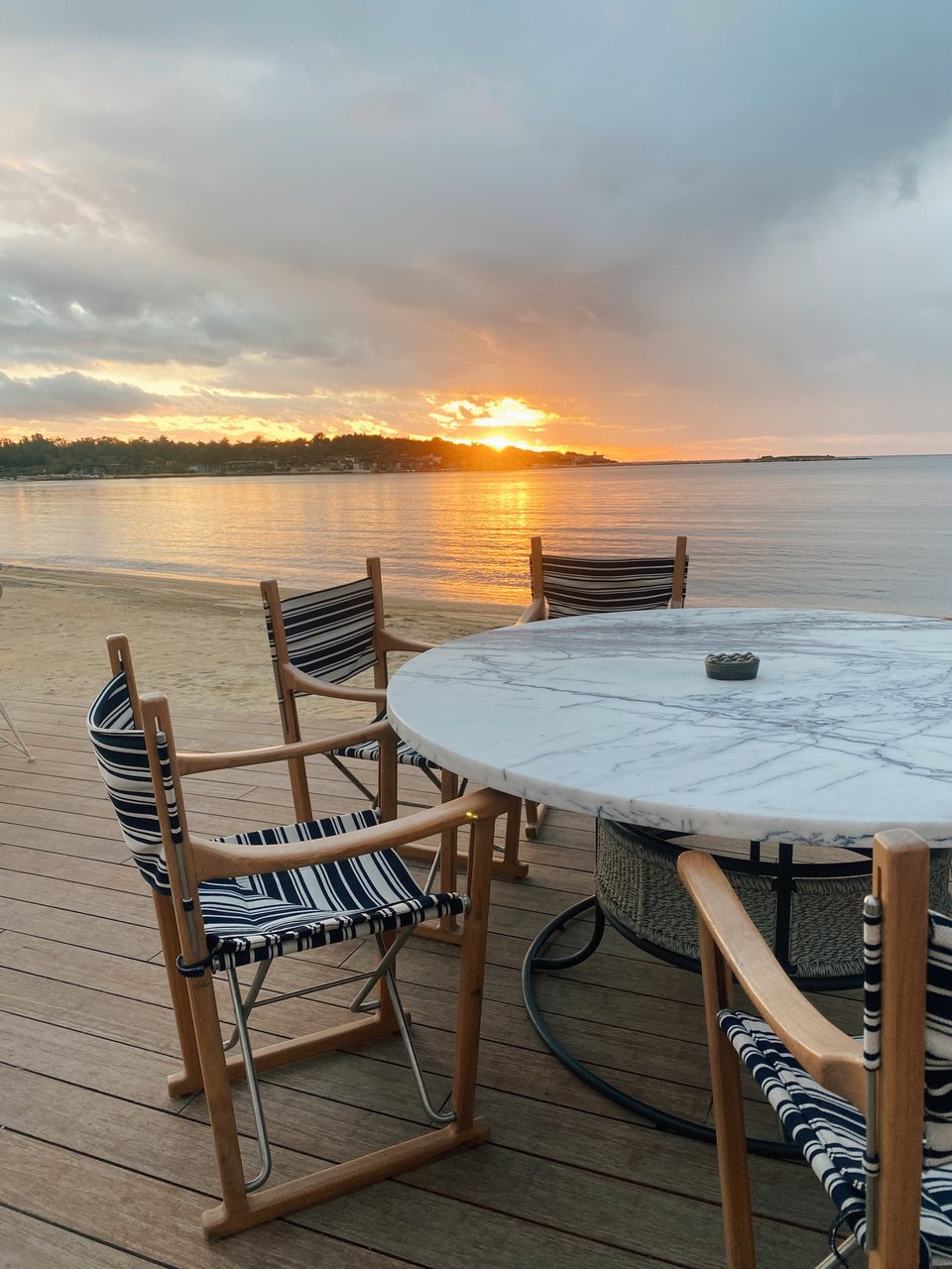 H θέα στο βροχερό ηλιοβασίλεμα από το ντεκ στην παραλία