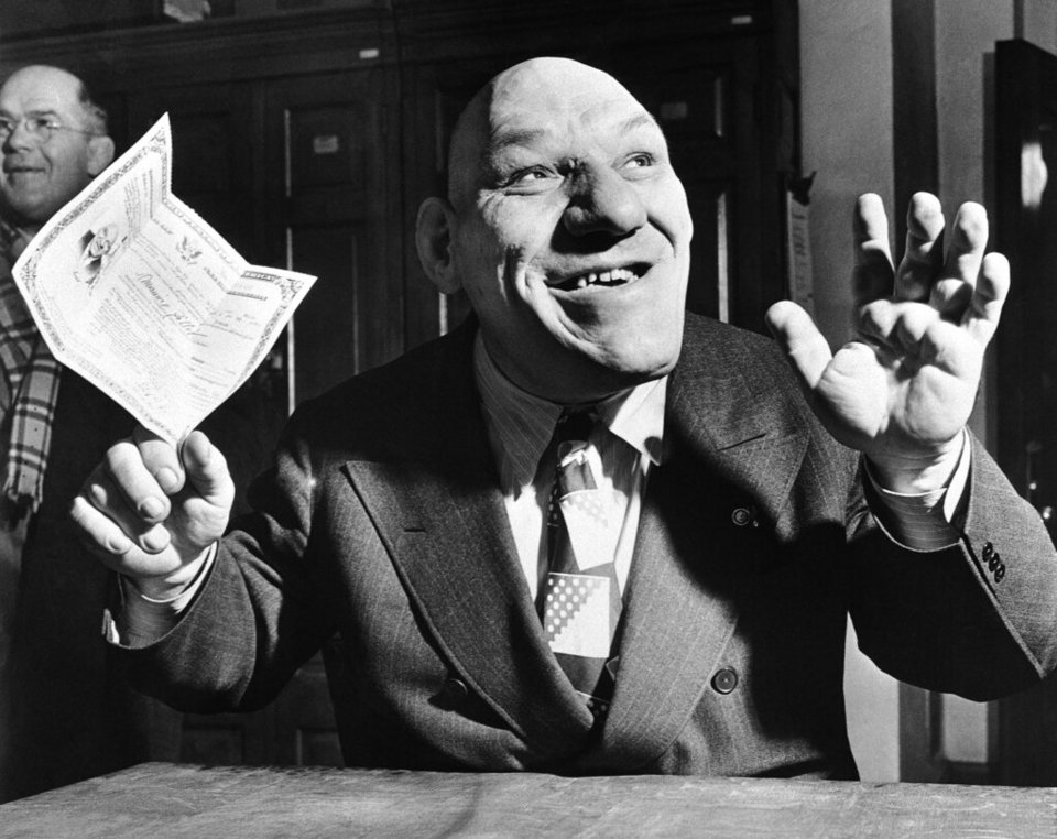 Ο Maurice "The Angel" Tillet, πάνω, ο 43χρονος Γάλλος παλαιστής χαμογελά καθώς κρατά τα χαρτιά της υπηκοότητάς του, αφού έγινε πολίτης των ΗΠΑ