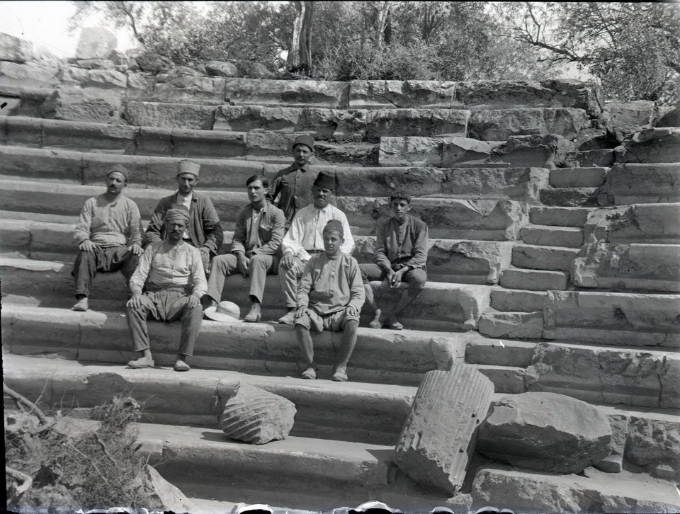 Νύσα του ποταμού Μαιάνδρου, Αύγουστος 1921. Ο νεαρός αρχαιολόγος Νικόλαος Λάσκαρης και επτά εργάτες της ανασκαφής κάθονται στα εδώλια του Γεροντικού – το αρχαίο Βουλευτήριο της πόλης (Φωτογραφικό Αρχείο Εθνικού Αρχαιολογικού Μουσείου)