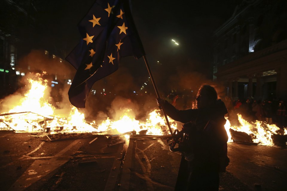 Διαδηλώτρια κρατά στα χέρια της τη σημαία της ΕΕ / Φωτογραφία: AP Photo/Zurab Tsertsvadze