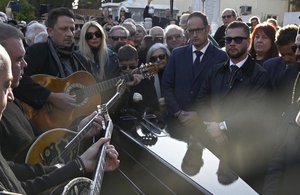 O Μανώλης Καραντίνης και οι μουσικοί του «συνοδεύουν» με κομμάτια της την Καίτη Γκρέυ στην τελευταία της κατοικία / Φωτογραφία: Intimenews