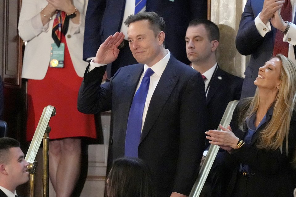 Ο Έλον Μασκ χαιρετίζει τον Τραμπ μέσα στην αίθουσα / Φωτογραφία: AP