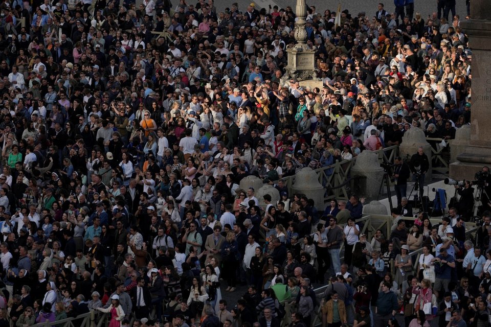 Πλήθος κόσμου έχει συγκεντρωθεί και περιμένει να δει τον καπνό που θα βγει