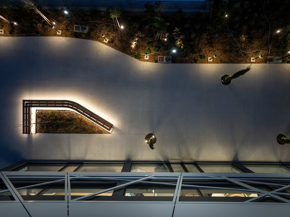 Ο εξωτερικός χώρος φωτογραφημένος από την ταράτσα του φουτουριστικού γραφείου με το λευκό μεταλλικό κέλυφος / Φωτογραφία: George Fakaros Photography - Courtesy of TAF | The Architectural Firm