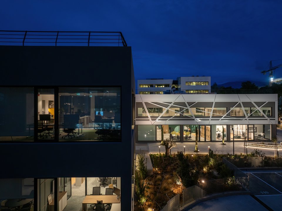 Νυχτερινή άποψη των δύο όγκων που αποτελούν τις δύο διαφορετικές όψεις των νέων γραφείων: η μοντερνιστική και η φουτουριστική / Φωτογραφία: George Fakaros Photography - Courtesy of TAF | The Architectural Firm