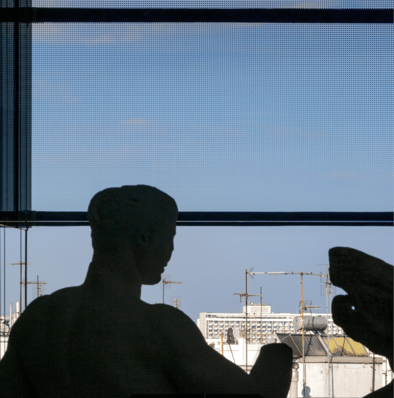 Ένα διαμελισμένο άγαλμα φωτογραφίζεται με φόντο ηλιακούς θερμοσίφωνες και κεραίες τηλεόρασης, αυτό το ιδιότυπο «αστικό δάσος»
