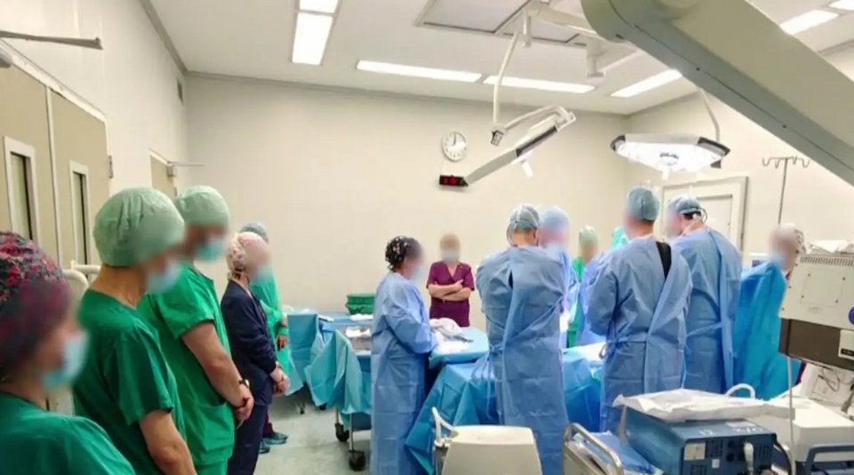 Οι γιατροί, στέκονται ακίνητοι και σιωπηλοί μπροστά στο χειρουργικό τραπέζι όπου κείτεται το νεκρό αγόρι