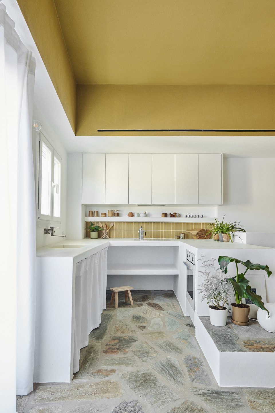 Η κουζίνα με τους χτιστούς πάγκους συνδυάζει το μοντέρνο minimal με το παραδοσιακό νησιώτικο στυλ / Φωτογραφία: Valiana Variantza - @blenderfactory