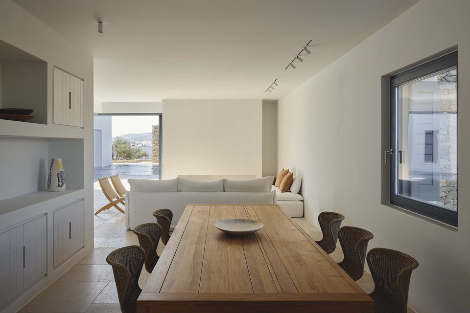 Η ξύλινη τραπεζαρία με τις ψάθινες design καρέκλες βρίσκεται σε μια εσοχή πλάι στο σαλόνι / Φωτογραφία: Giulio Ghirardi