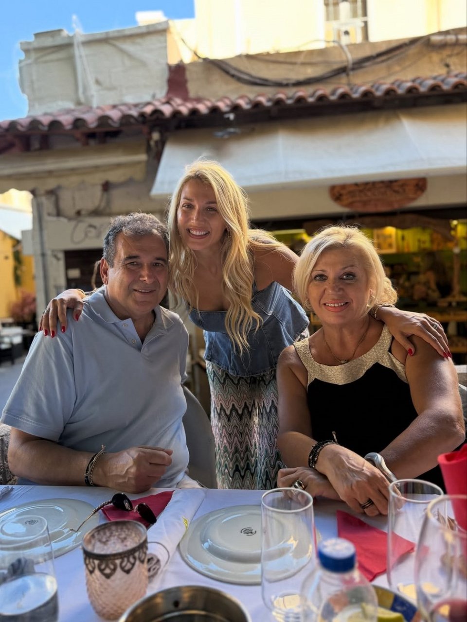 Η Κωνσταντίνα Σπυροπούλου ποζάρει χαμογελαστή ανάμεσα στους γονείς της