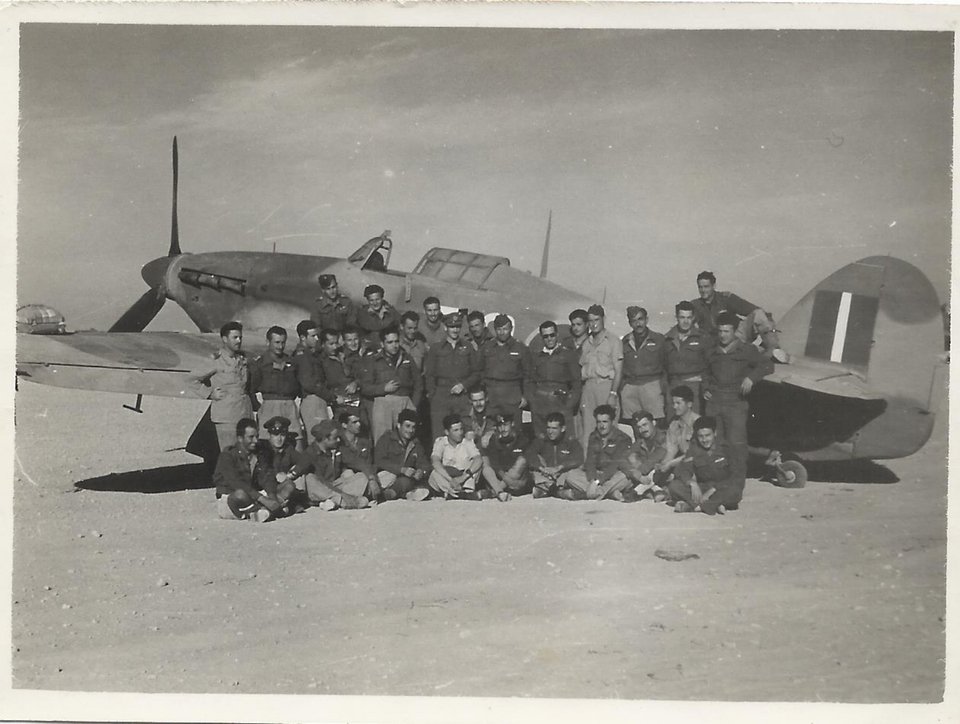 Στη φωτογραφία διακρίνονται πιλότοι της 335ης Μοίρας Διώξεως την περίοδο που επιτέθηκαν στο Ιταλικό Στρατηγείο στο Ελ Αλαμέιν, τον Οκτώβριο του 1942. Στο κέντρο με το δίκοχο ο επισμηναγός Ιωάννης Κέλλας, ο «πρώτος αετός της ερήμου». (προσωπικό αρχείο πτεράρχου Γεωργίου Πλειώνη)