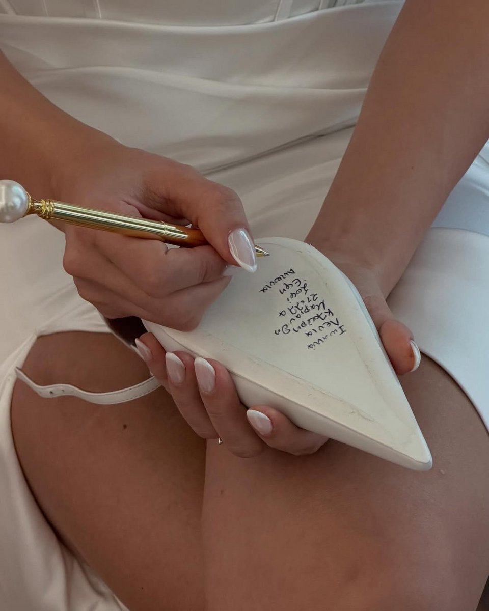 Η νύφη γράφει τα ονόματα στο παπούτσι