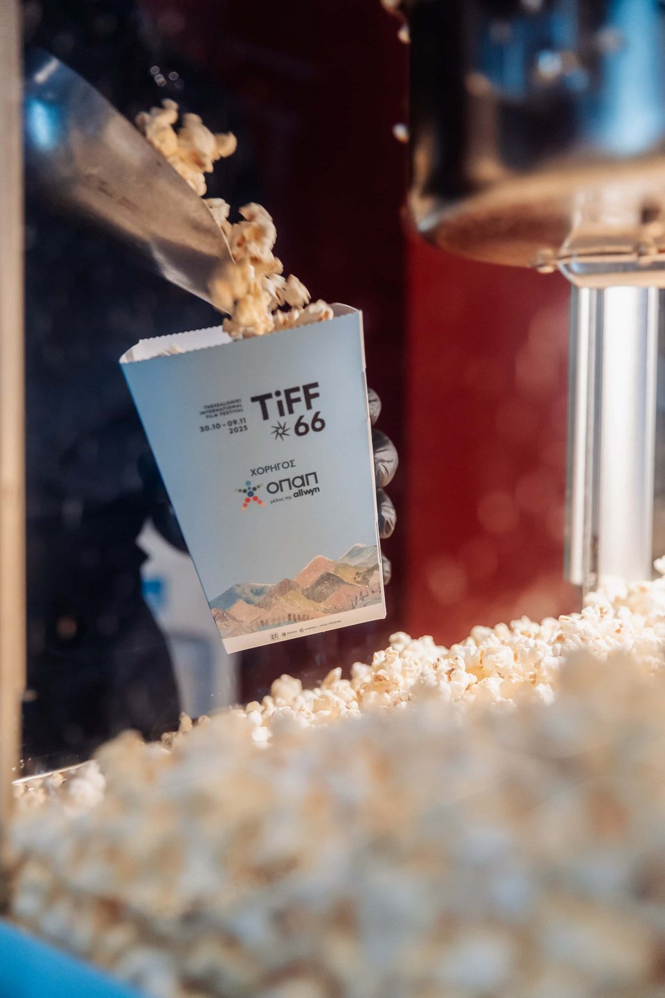 Ο κόσμος παραλαμβάνει popcorn από το station του ΟΠΑΠ για την προβολή της ταινίας Grand Prix 