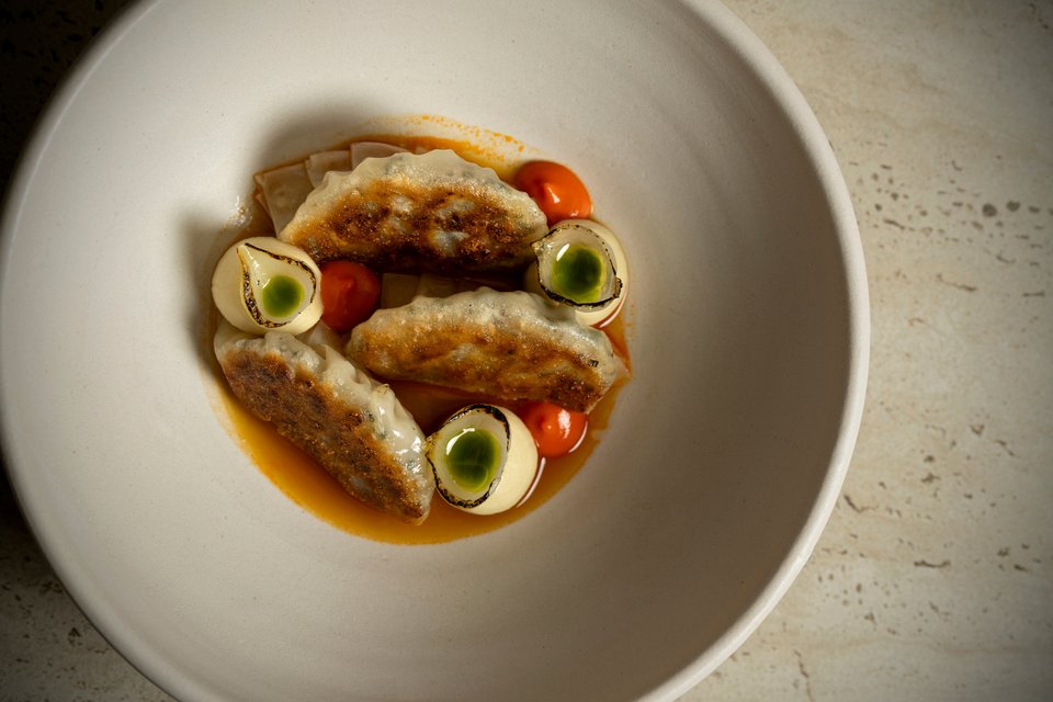 Γκιόζα με λουκάνικο, ζωμό σπετσοφάι και κρέμα κόκκινης πιπεριάς / Φωτογραφία: Anthes