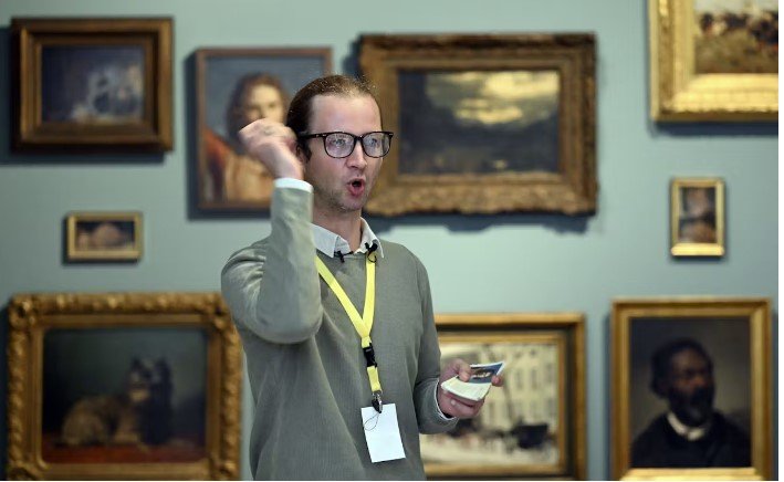 Πίσω απ’ αυτή την επιθετική ρητορική κρύβεται ο Carl Brandi, ένας Γερμανός performance artist, ο οποίος δημιούργησε τον άξεστο ξενάγο για να ανατρέψει τη συμβατική σχέση ανάμεσα στον ειδικό και τον θεατή / FACEBOOK 