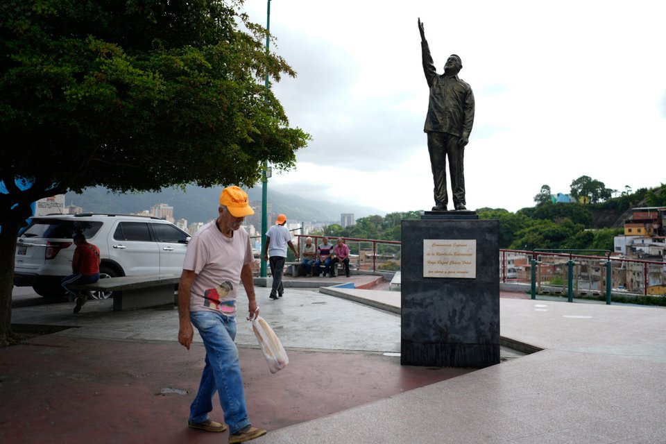 Φτωχοί κάτοικοι του Καράκας στη Βενεζουέλα, δίπλα στο άγαλμα του Ούγκο Τσάβες / AP