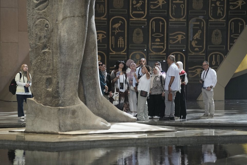 Τουρίστες στέκονται κάτω από το άγαλμα του Φαραώ Ραμσή ΙΙ, στο Μεγάλο Αιγυπτιακό Μουσείο / ΑP