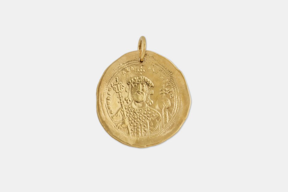 Πιστό αντίγραφο χρυσού νομίσματος του Κωνσταντίνου Θ’ Μονομάχου (1042 1055). Στη μία όψη εικονίζεται ο αυτοκράτορας, φορώντας διάδημα με σταυρό. Με το δεξί χέρι κρατά σκήπτρο, ενώ με το αριστερό κρατά σταυροφόρα σφαίρα. Στην άλλη όψη εικονίζεται ο Χριστός ένθρο νος. Με το δεξί χέρι ευλογεί και με το αριστερό κρατά Ευαγγέλιο. Περιμετρικά, υπάρχει επιγραφή και στις δύο όψεις. Τιμή: 42,00€