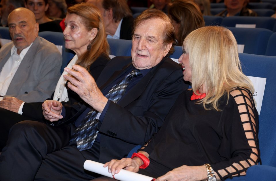 Ο Γιώργος Κωνσταντίνου μιλάει με την Άννα Φόνσου και στο βάθος φαίνονται η Αιμιλία Υψηλάντη με τον Δημήτρη Καλλιβωκά