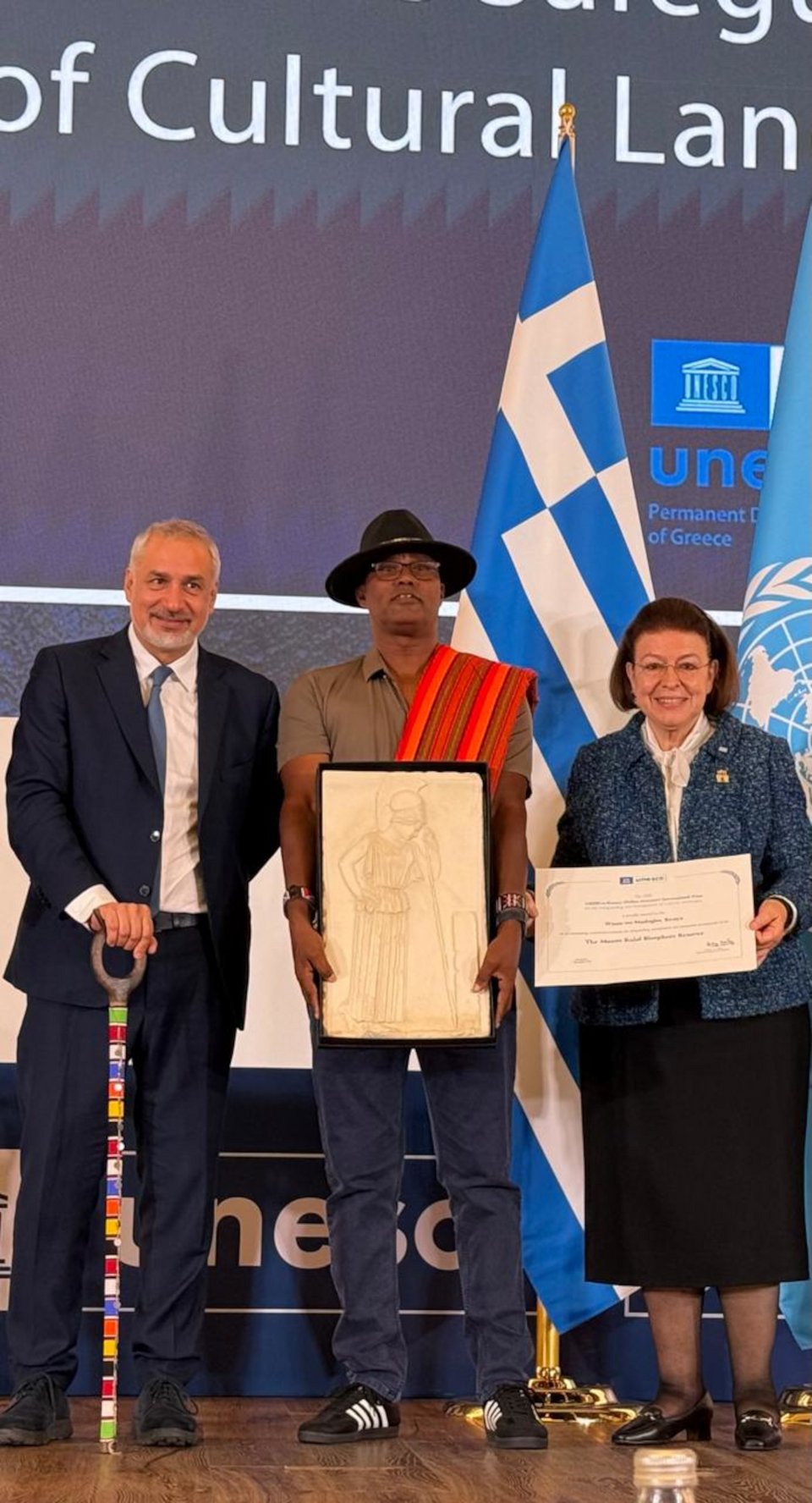 Ο Αναπληρωτής Διευθυντής Πολιτισμού της UNESCO Ερνέστο Οττόνε, ο επικεφαλής της κοινότητας Wazee wa Mazingira και η Υπουργός Λίνα Μενδώνη κατά την τελετής της απονομής