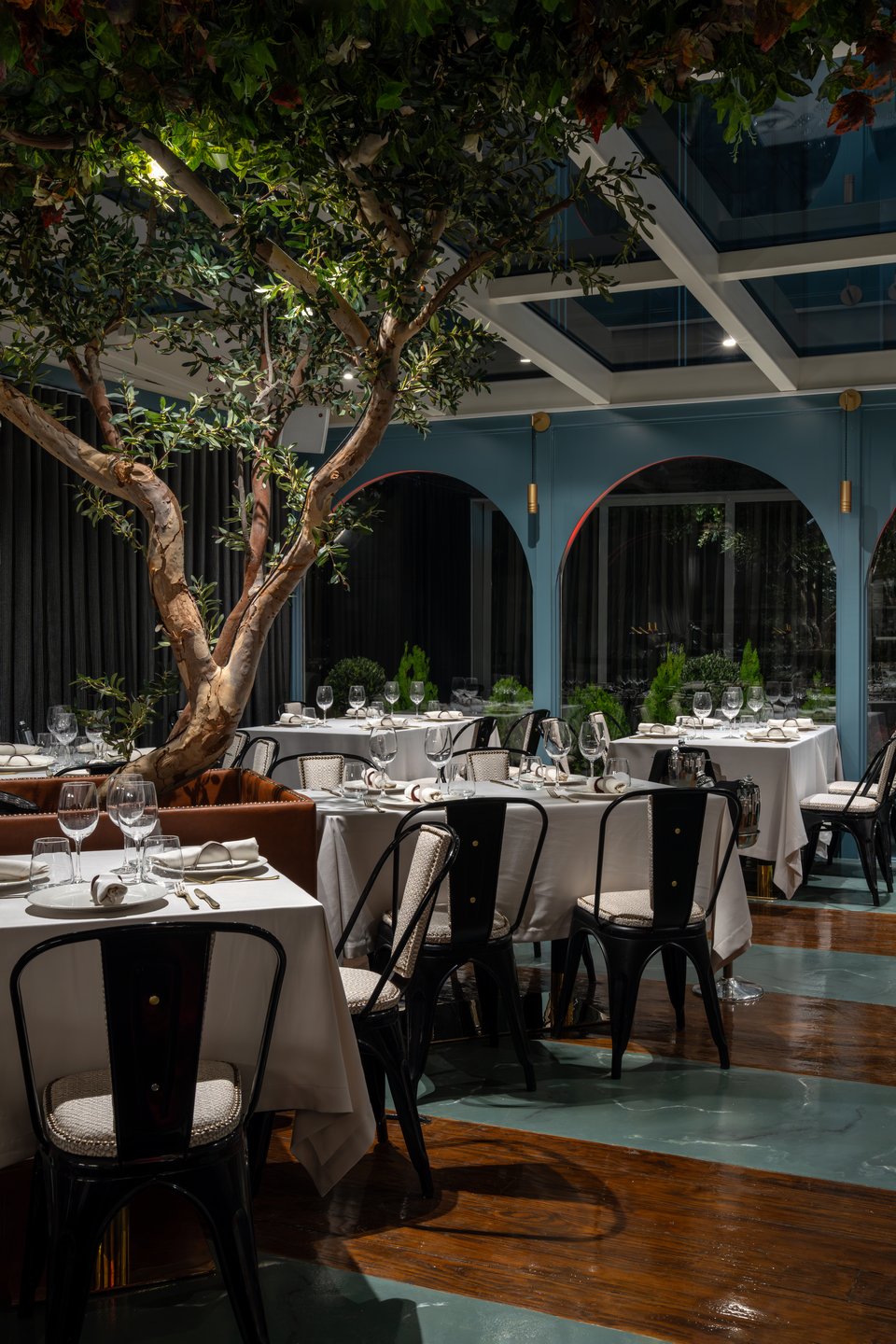 Καρέκλες τύπου Tolix από γαλλικό μπιστρό σπάνε την επισημότητα των λευκών τραπεζομάντιλων.