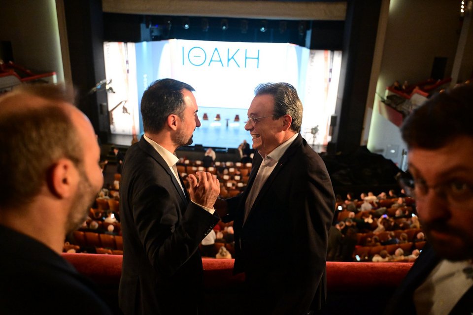 Χαρίτσης-Φάμελλος γελούν στις θέσεις τους αναμένοντας την έναρξη της εκδήλωσης